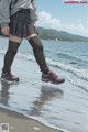 A woman walking on a beach next to the ocean.