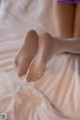 A close up of a woman's legs on a bed.