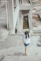 A woman standing on the ground in front of a building.