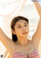 A woman in a bikini posing on the beach.