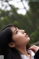 A woman with long black hair looking up at the sky.