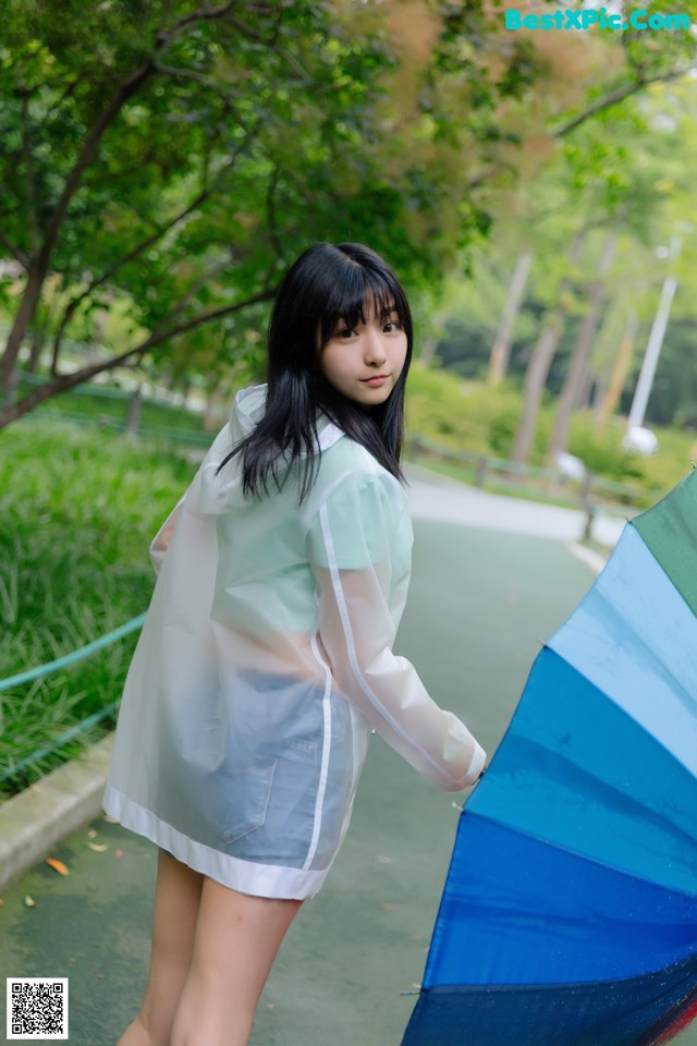 A woman in a white dress holding an umbrella.