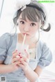 A woman in a blue dress holding a glass of milk.